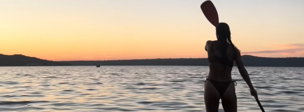 girl on paddleboard at sunset