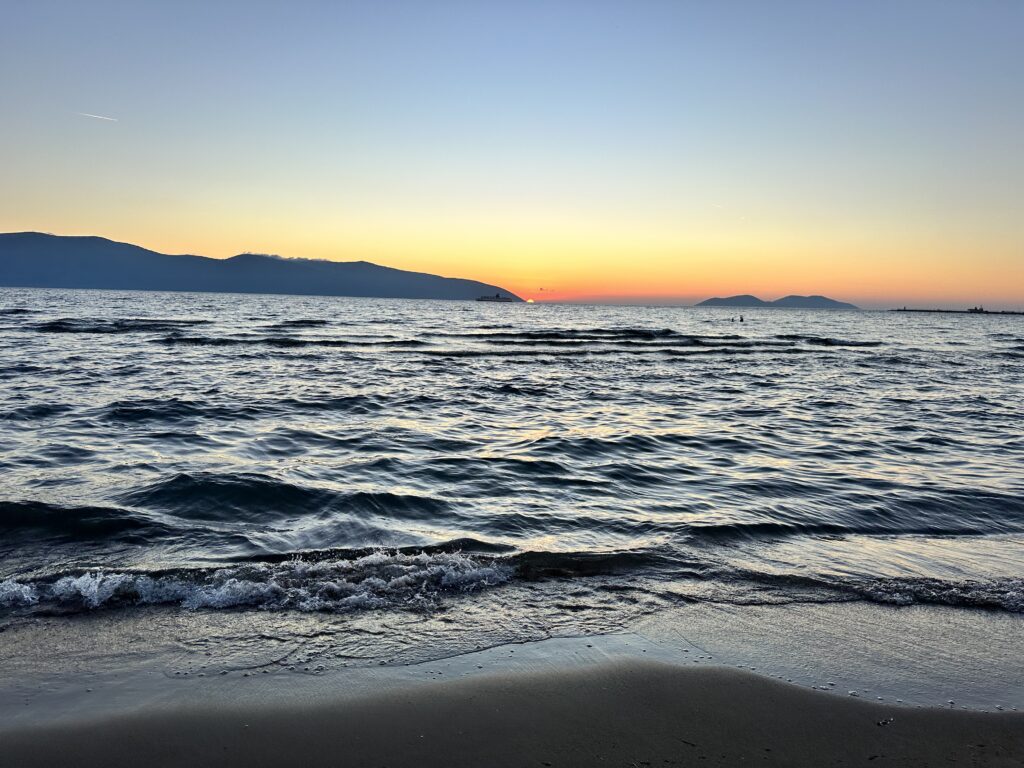 sunset over ocean with mountains behind